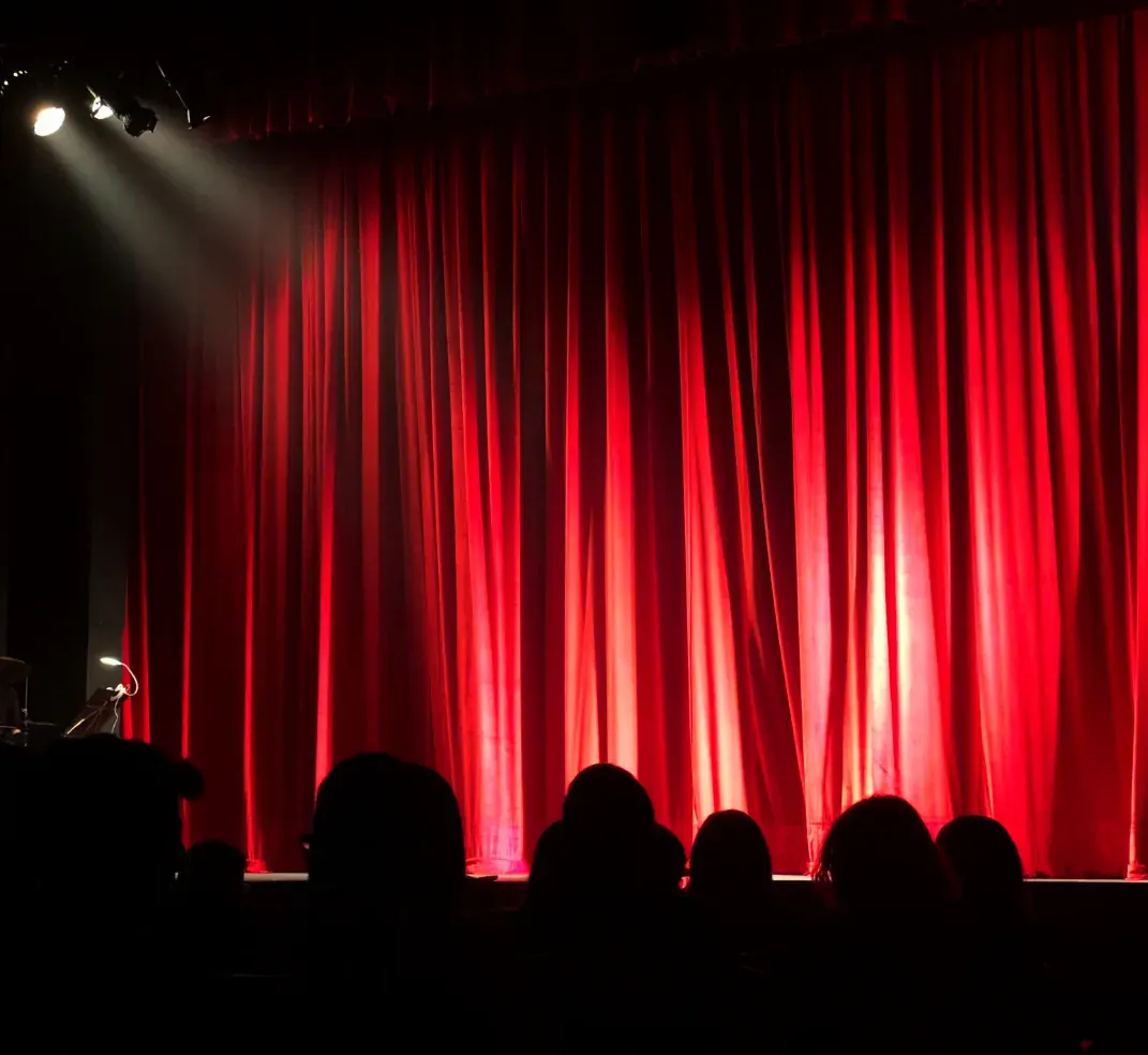 Escenario del Teatro Victoria de Madrid con el telón rojo iluminado